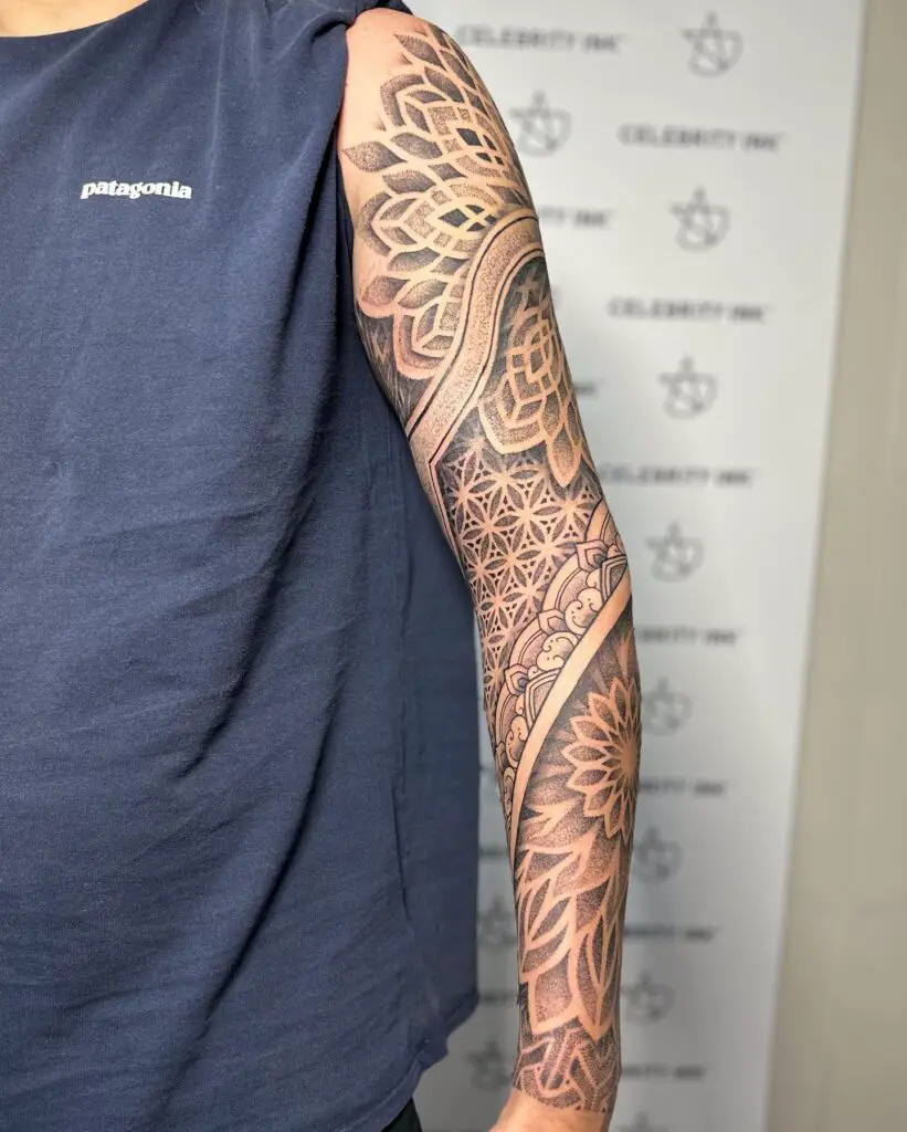 Full arm sleeve tattoo featuring geometric and floral mandala patterns in a black ink gradient.