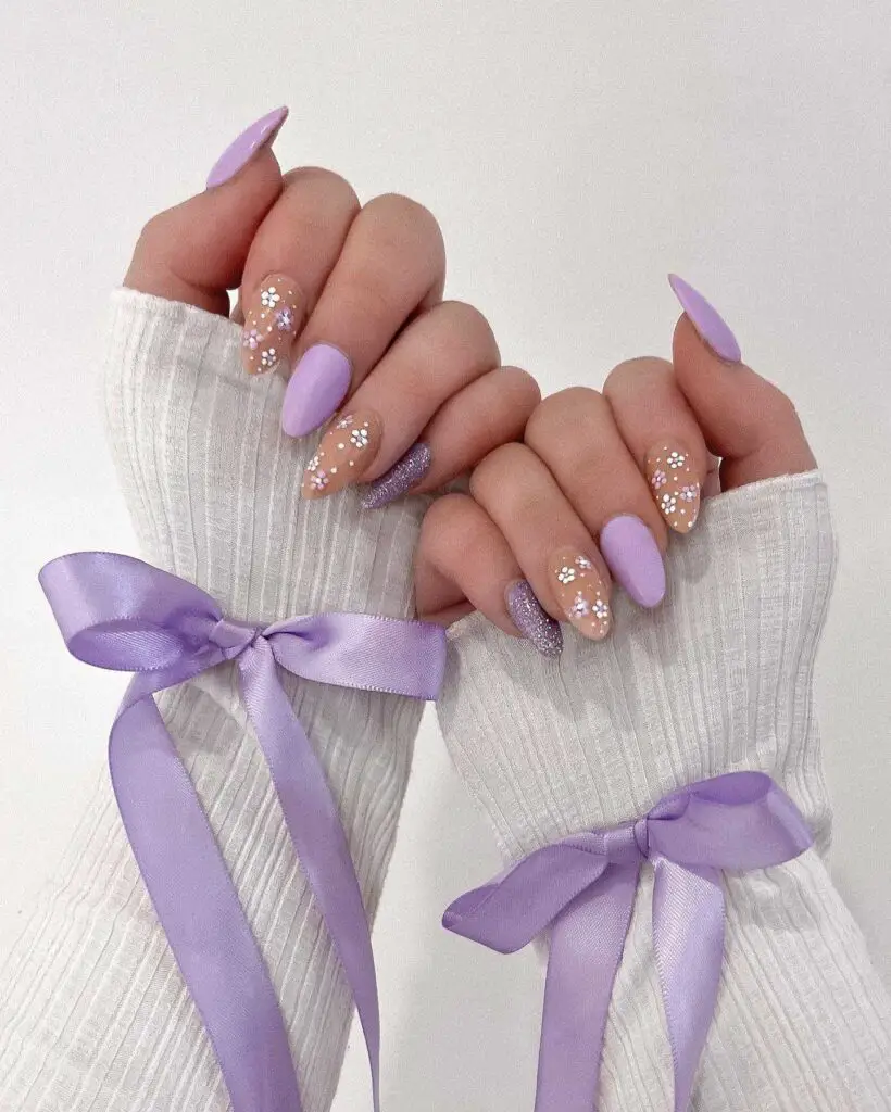 Pastel lavender nails with floral glitter design, perfect for a spring-inspired look.