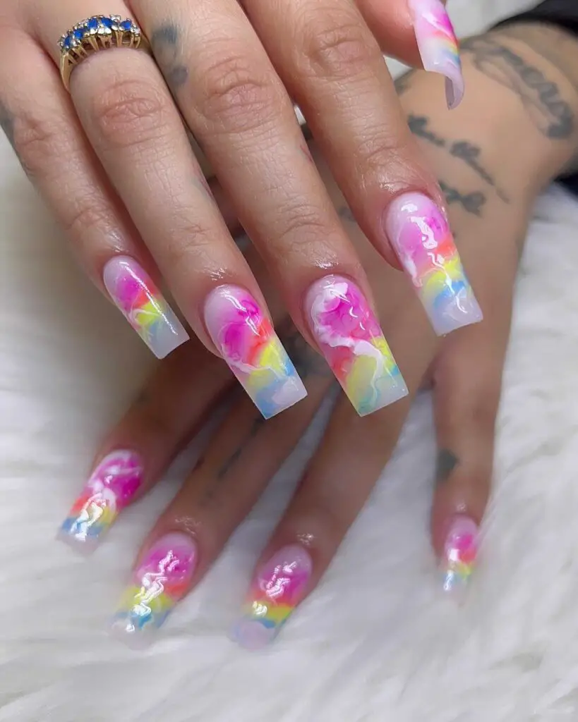 Long acrylic nails with a swirling mix of pastel candy colors, giving the impression of whimsical clouds.