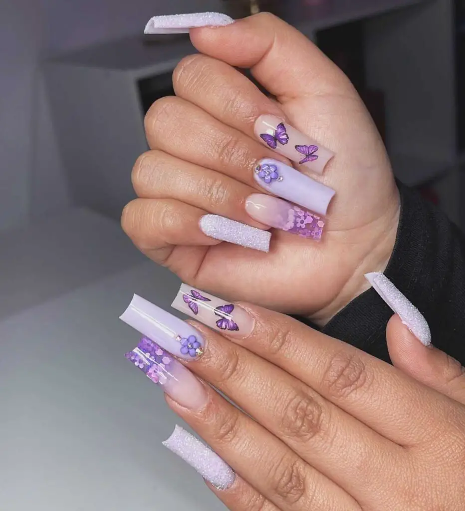Long square nails with a lavender gradient and delicate butterfly and floral accents, exuding a whimsical charm.