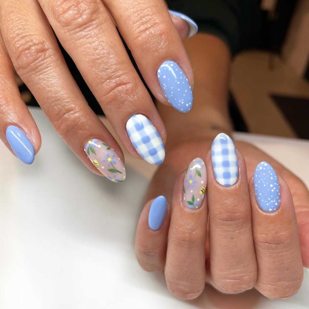 A playful mix of nail designs featuring blue gingham, polka dots, and floral patterns for a vibrant and cheerful look.