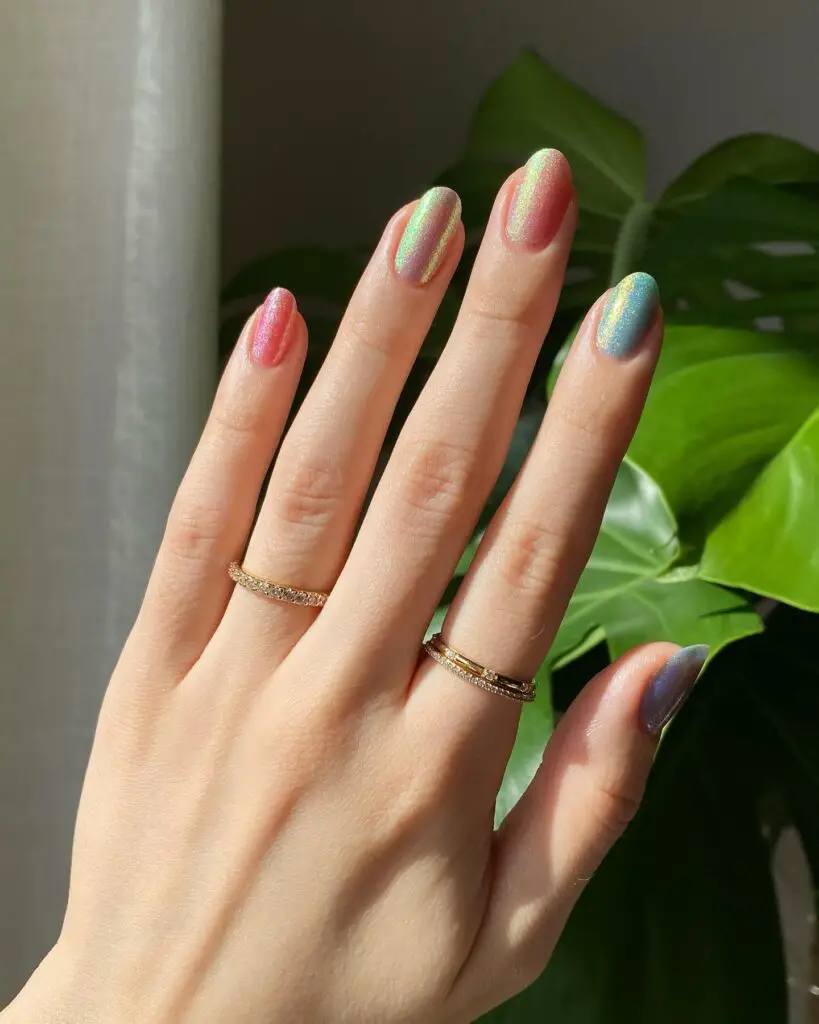 Trendsetting nails with multi-chromatic holographic polish, displaying a shimmering color change effect under the light.