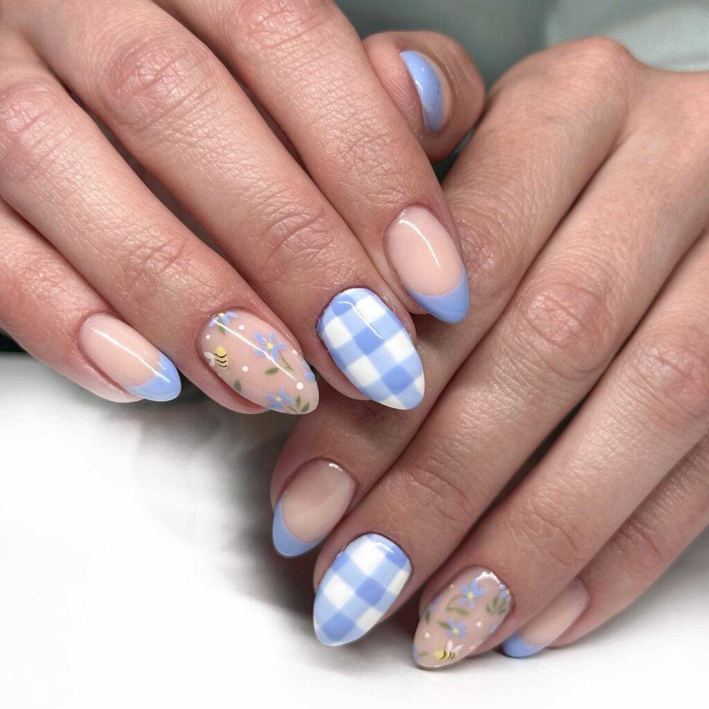 Hands with nails featuring blue gingham and pink floral nail art, perfect for a springtime aesthetic.