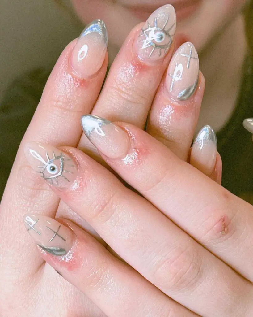 Glossy nails with mystical symbols including anchors and eyes, set against a pearly background for a nautical theme.