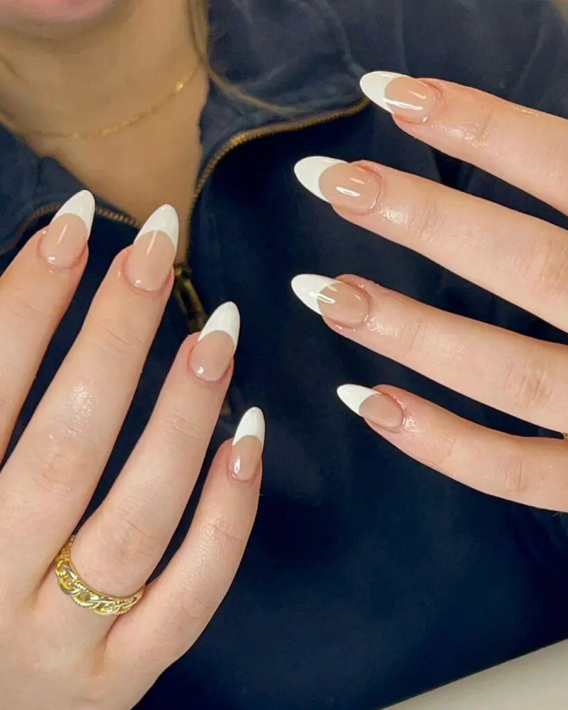 Almond-shaped nails with a chic ombré transition from white to nude, blending modern style with elegance.