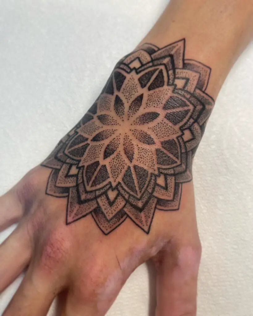 A forearm tattoo with a sleek and modern geometric mandala design, featuring clean lines and contrasting elements.