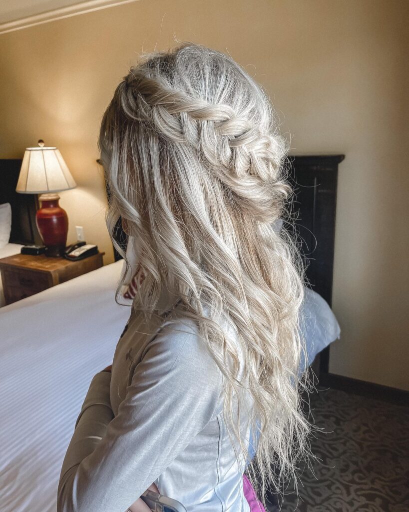 A blonde hairstyle with half-up twists and tousled waves, offering a romantic and dreamy look for prom.