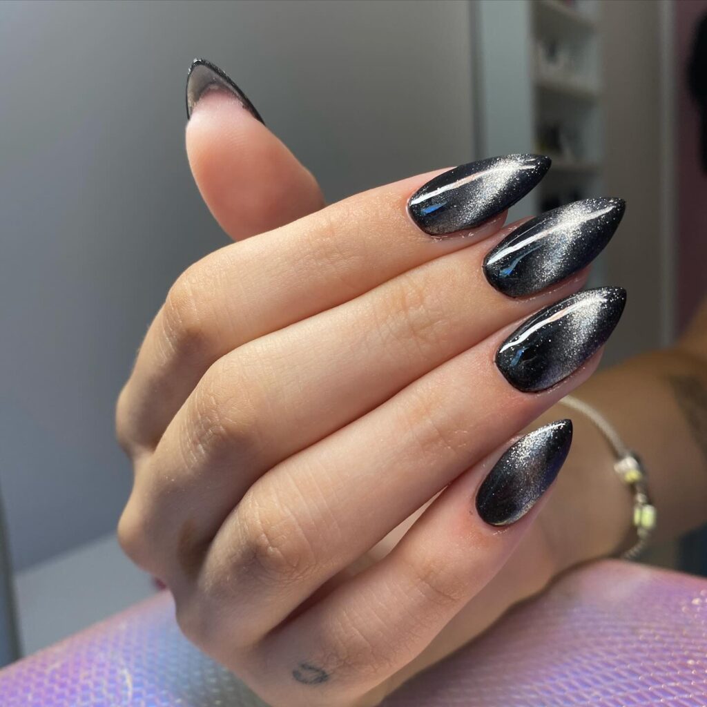 Cosmic Sleek: Dive into the deep space of glossy black nails with silver speckles, crafting a sophisticated rendition of the infinite galaxy.
