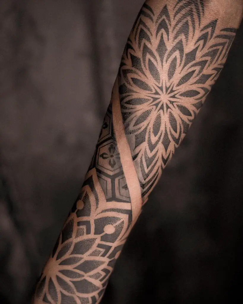 An arm tattoo of a mandala with shadow effects creating a sense of depth and dimensionality.