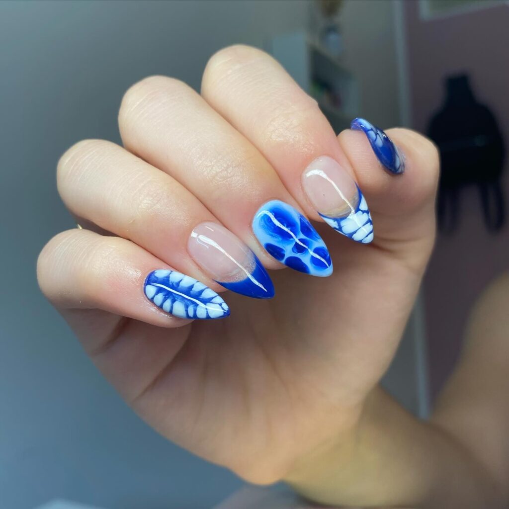 Oceanic Vibrance: Dive into deep blue waves with a nail design that captures the essence of the ocean's undulating beauty, complete with a splash of white.