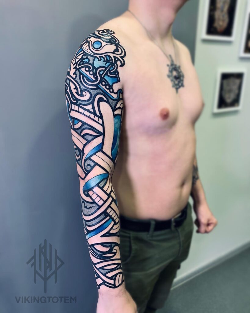 An artistic Norse dragon sleeve tattoo in bold blue, intertwined with traditional Viking patterns.