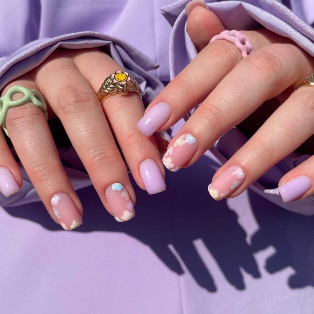 Soft purple nails with cloud designs in French tip style, capturing a slice of the spring sky.