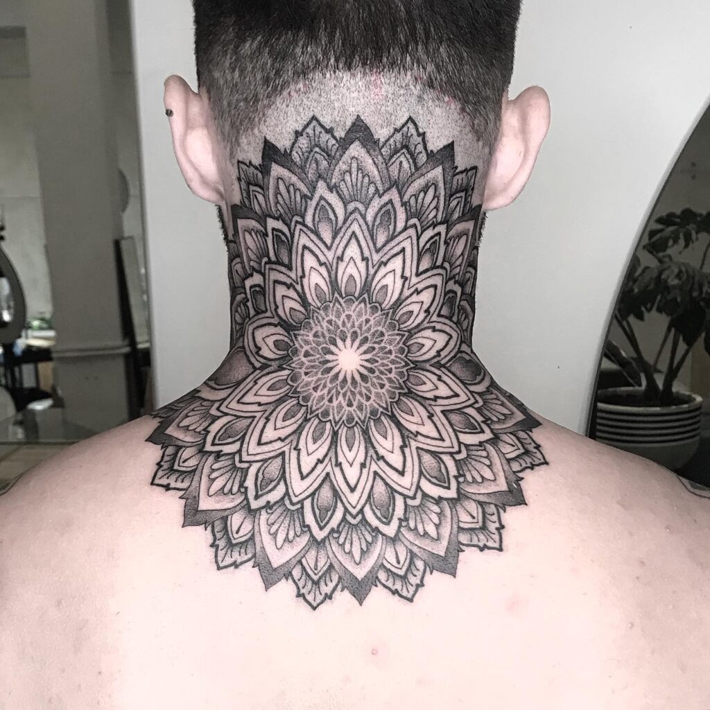 An ornate mandala tattoo on the back of the neck with layered geometric patterns and petal designs.
