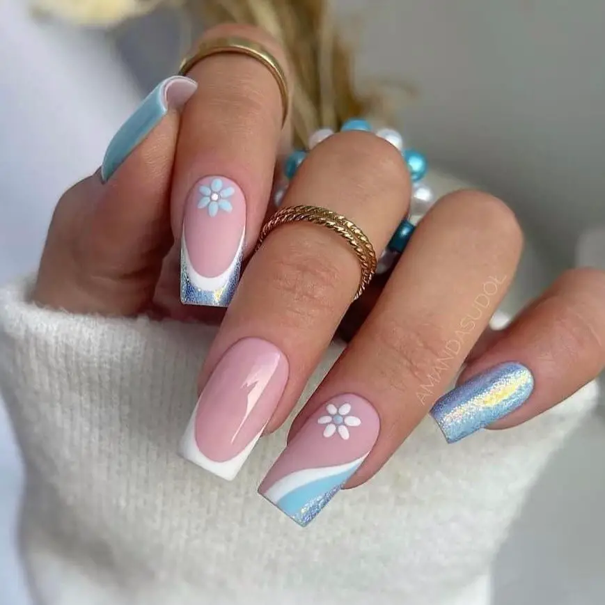 Icy Elegance: This nail design's cool blue and soft pink tones with sparkling silver evoke the serene beauty of a frost-covered flower garden.