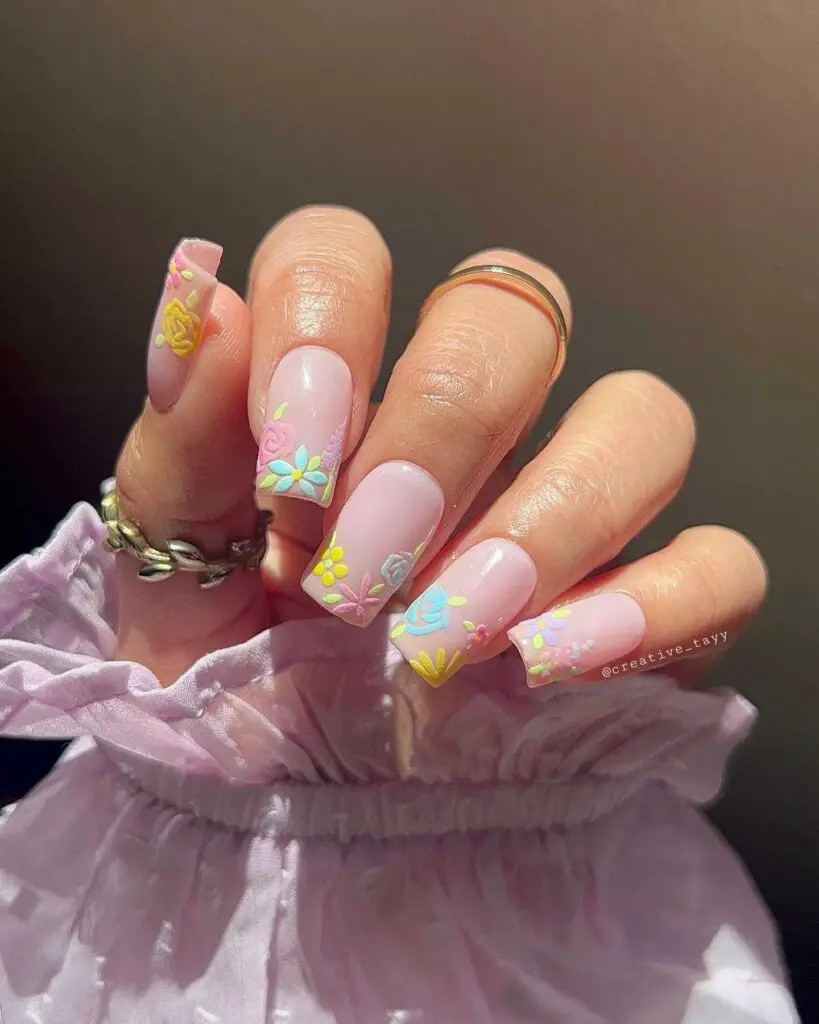 Nails with a pastel pink base featuring raised floral art, perfect for those who want to carry the essence of a spring garden with them.