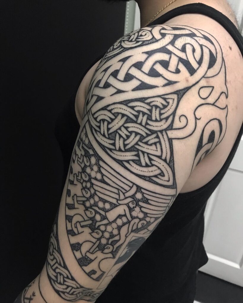 A full sleeve tattoo with the Yggdrasil tree and various Norse mythological elements in detailed knotwork.