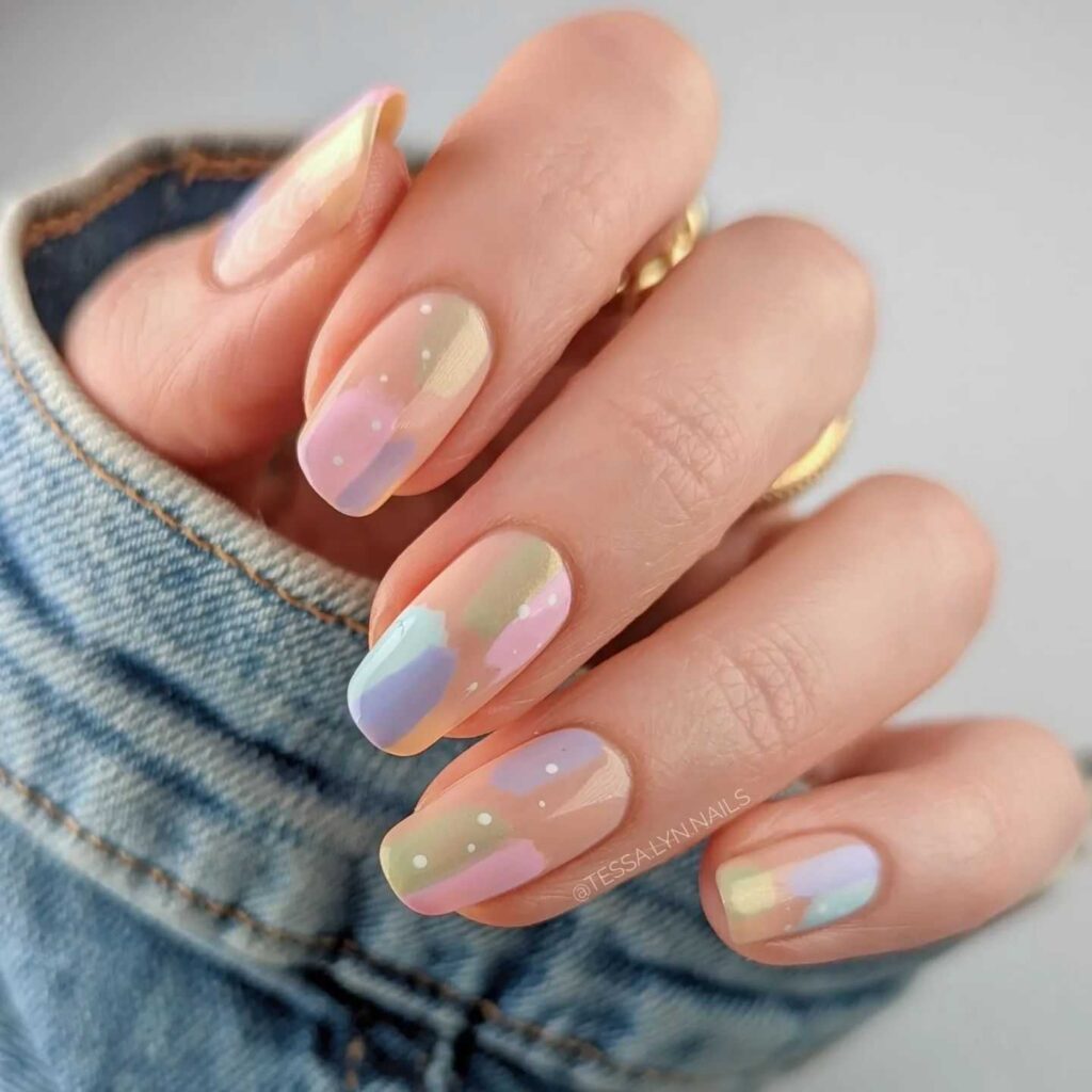 Nails with a glossy finish featuring a pastel rainbow gradient, combining playful colors with a sophisticated sheen for a spring-ready manicure.