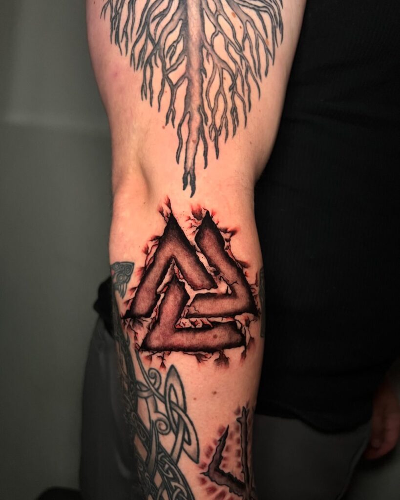 A tattoo featuring Yggdrasil with roots in the form of runes, symbolizing the Norse tree of life.