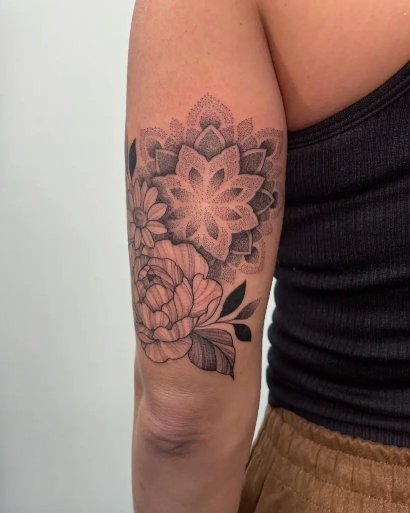 A forearm tattoo featuring a blend of a blooming flower and mandala patterns.