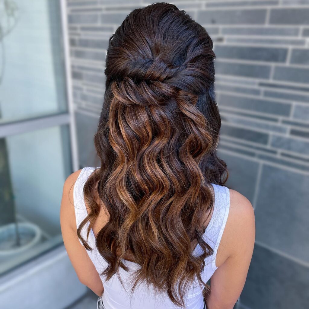 A woman with a braided headband and full, wavy hair, ready for a boho-chic prom night.