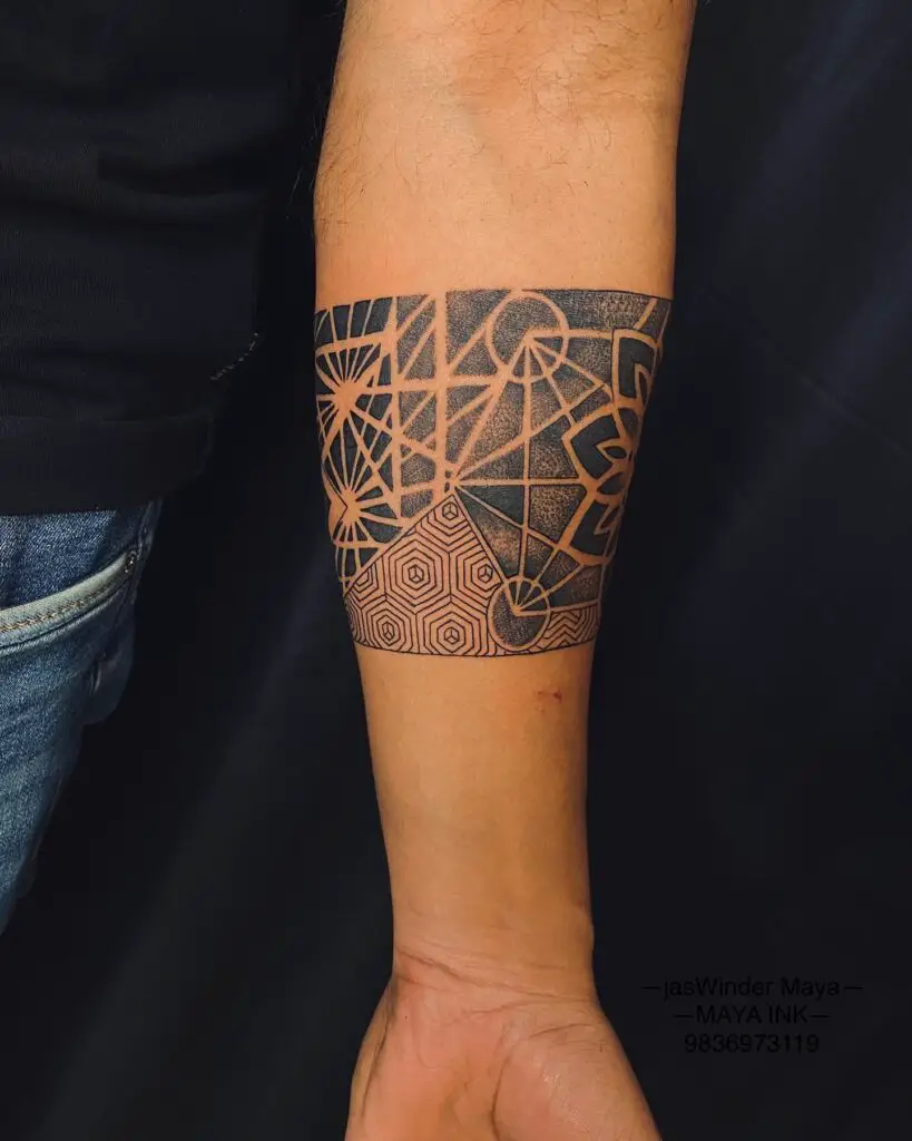 A forearm band tattoo with a modern geometric mandala design, highlighting sharp angles and clean lines.