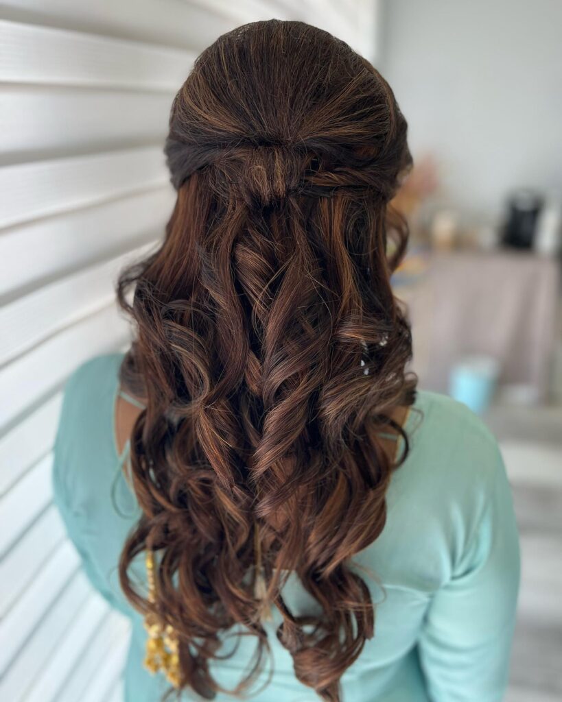 A half-up twist with cascading dark waves, styled for an elegant and graceful prom hairstyle.