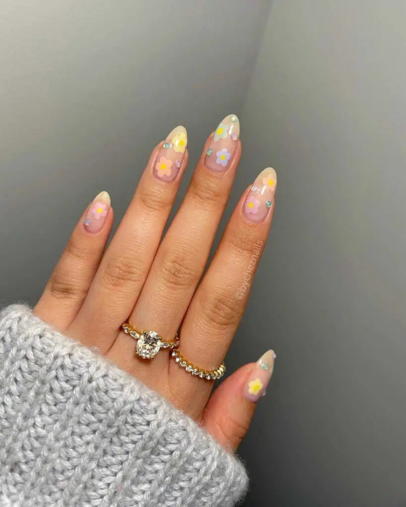Hand with nails decorated with small pastel floral decals, encapsulating the delicate charm of spring blossoms.