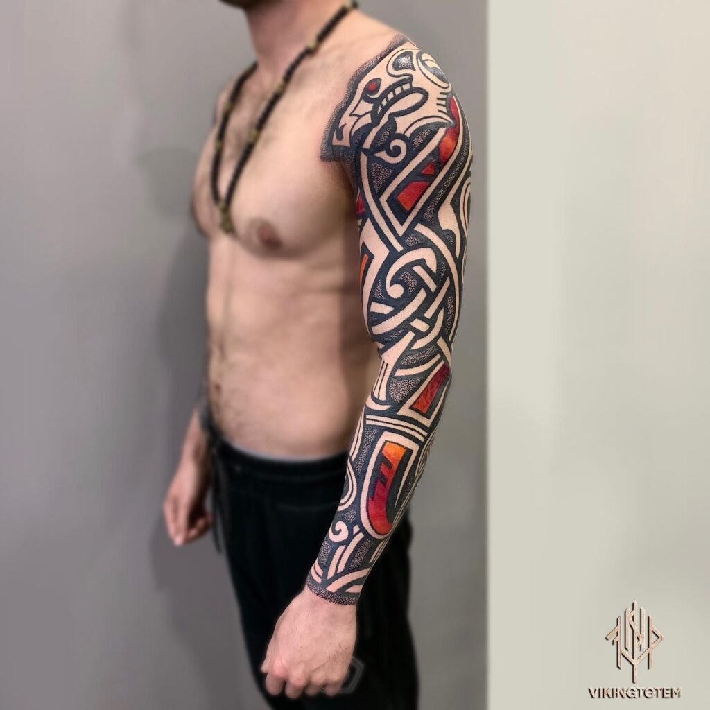 A Viking warrior-themed tattoo sleeve with traditional symbols in red and black.