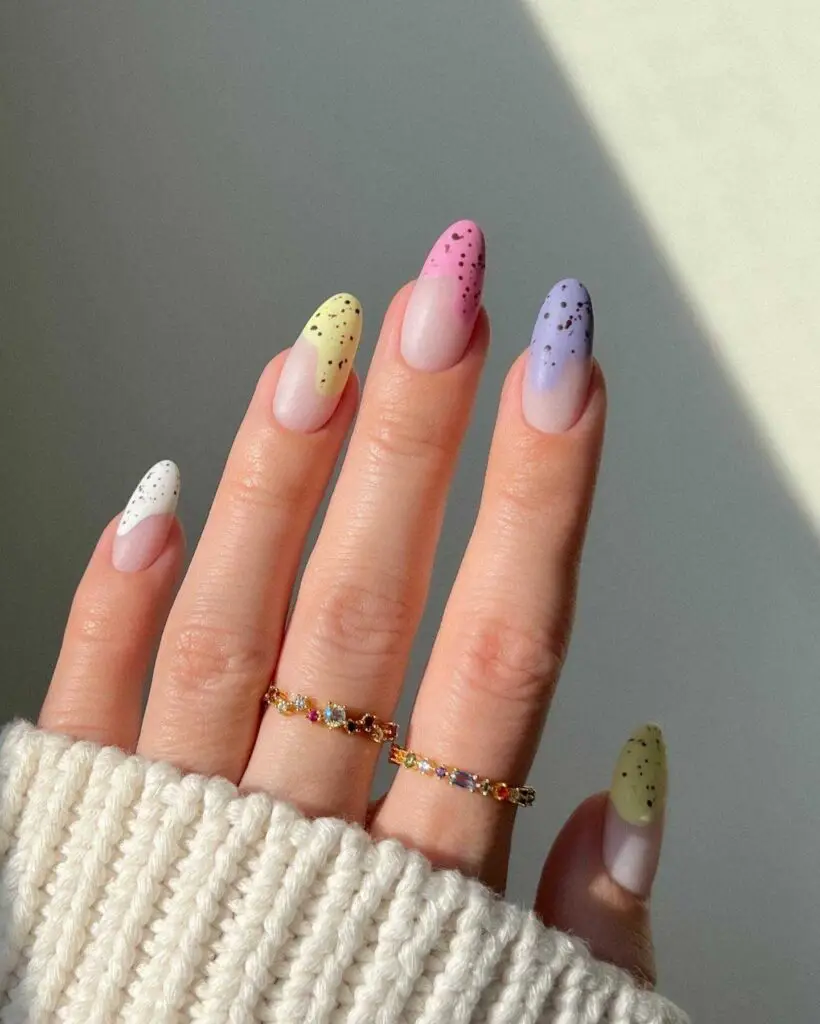Gradient ombre nails in pastel shades with speckled details, echoing the essence of spring.