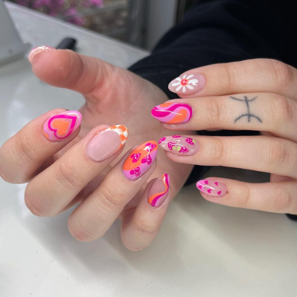 Artistic Vibrancy: Bold pinks and oranges come together with unique patterns in a nail design that channels the vivid energy of pop art.