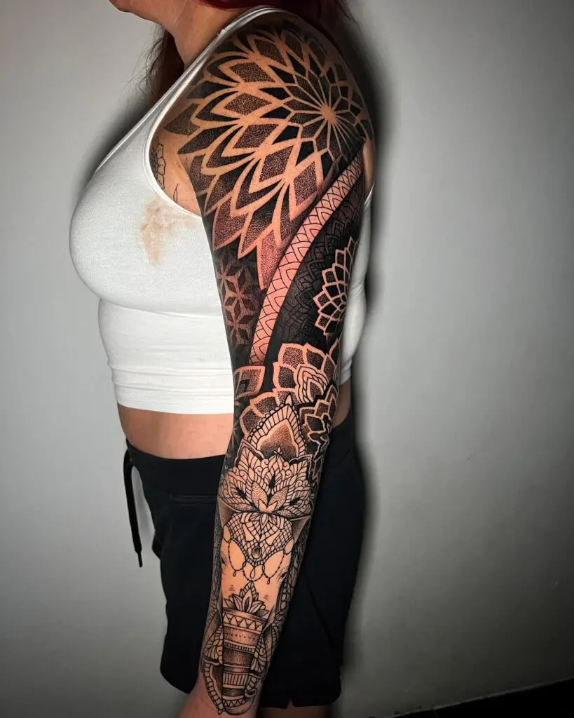 A full sleeve tattoo with alternating mandala patterns and solid black geometric shapes, emphasizing contrast and detail.