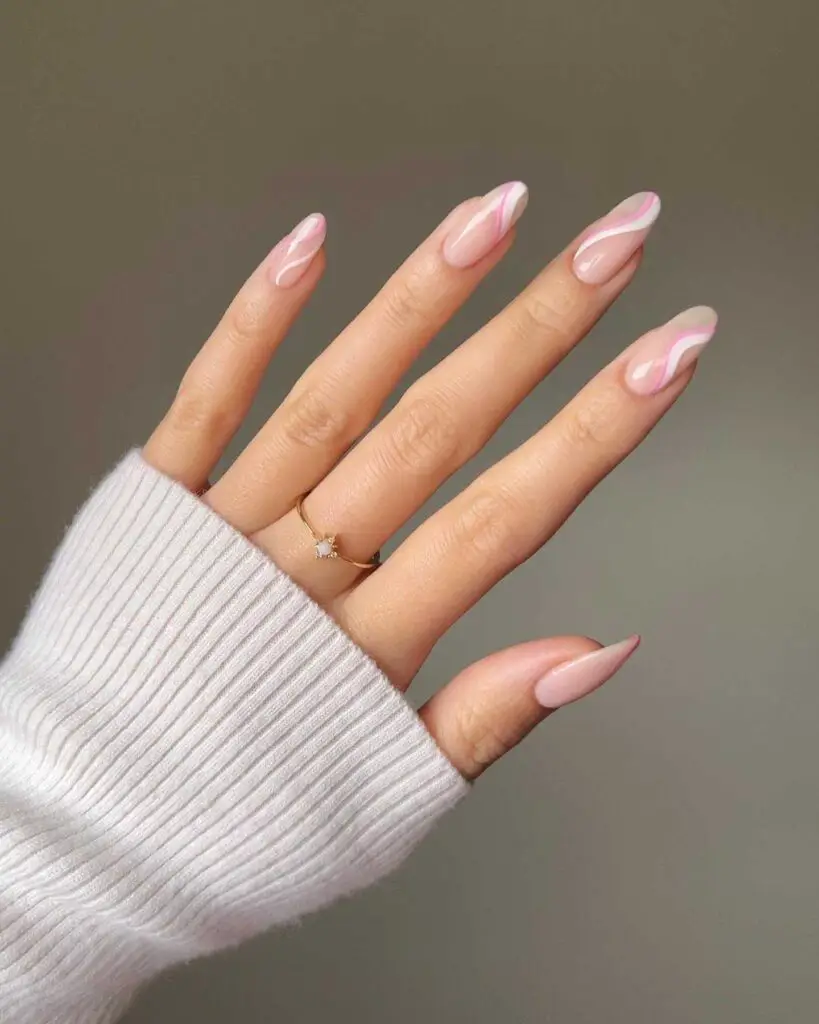 Hand with soft pink nails enhanced by elegant white swirl designs, embodying understated sophistication suitable for springtime fashion.