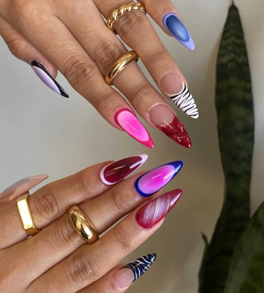 A display of long, stiletto nails painted in vibrant colors and patterns, embodying boldness and artistic expression.