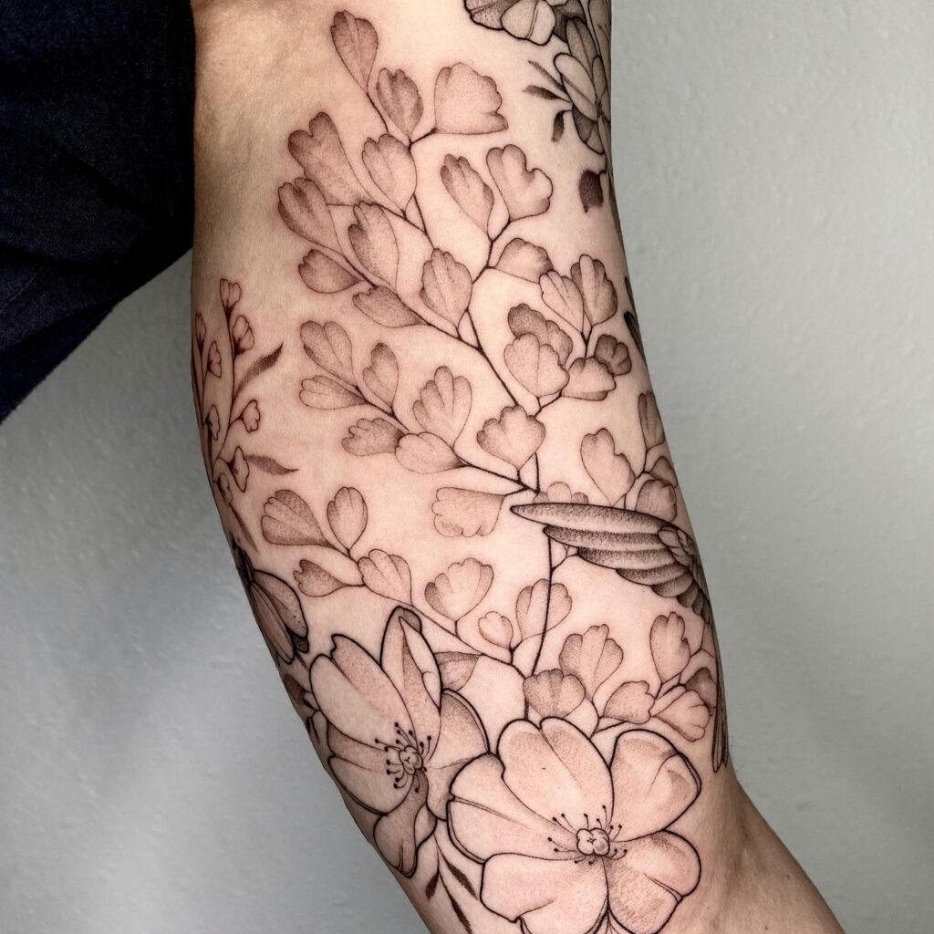 A sleeve tattoo with detailed flowers and leaves, symbolizing growth and natural elegance.