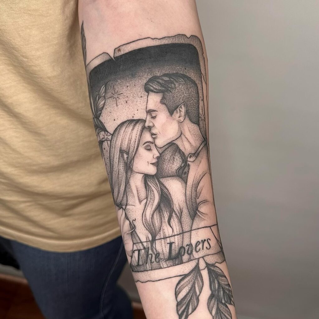 A forearm tattoo depicting 'The Lovers' from the tarot, focusing on their intimate embrace, encapsulated within leafy motifs.