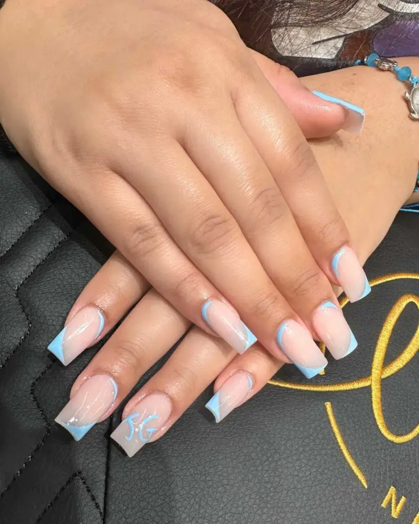 A hand showing nails with a clear nude base and gentle skyline blue French tips, accented with a fine white line for a chic look.
