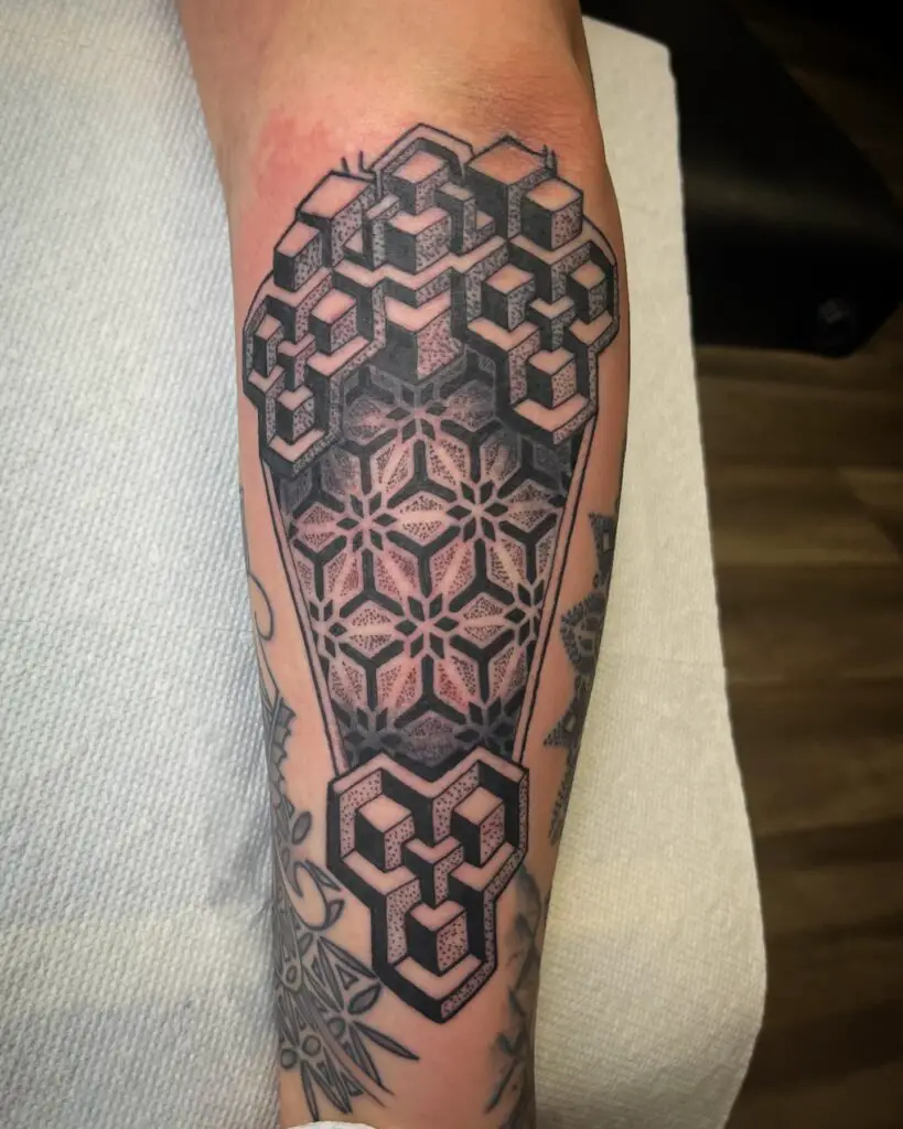 A forearm tattoo with interlocking hexagons transitioning into a detailed mandala design.