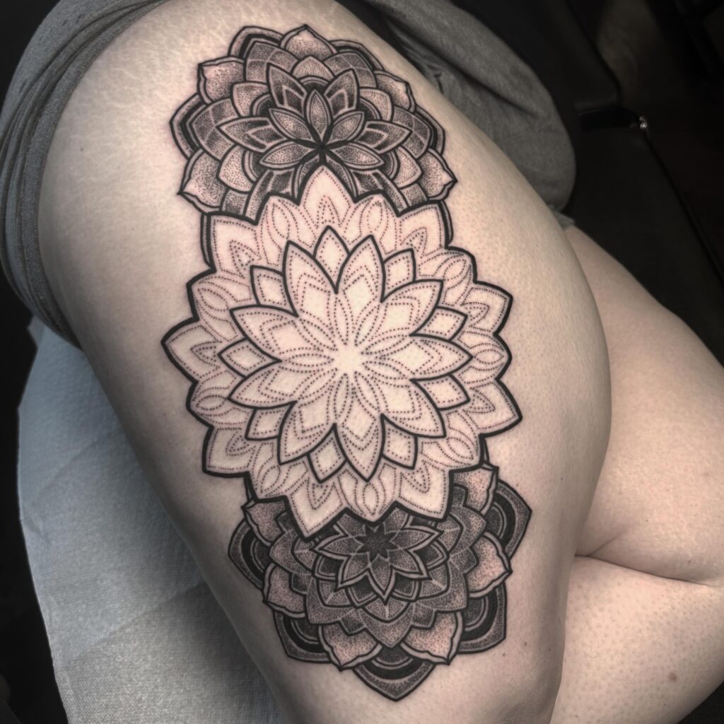 A forearm tattoo with three stacked lotus mandala designs, each intricately detailed and varying in size.