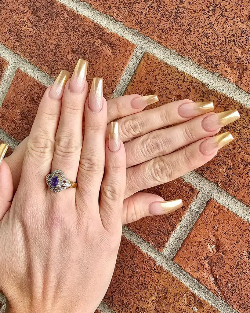 Elegant manicure with metallic gold tips on a nude nail base, providing a luxurious and sophisticated look ideal for evening events.