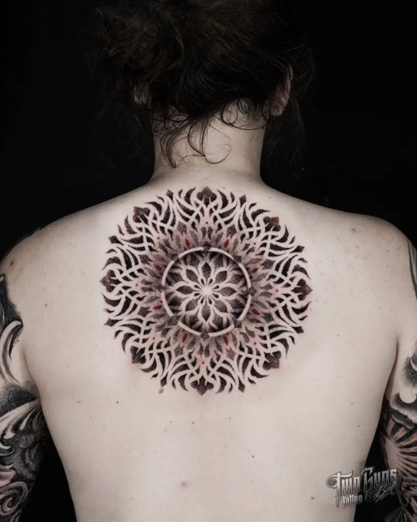 A large, symmetrical mandala tattoo on the back, with leaf and petal designs suggesting a blooming garden.