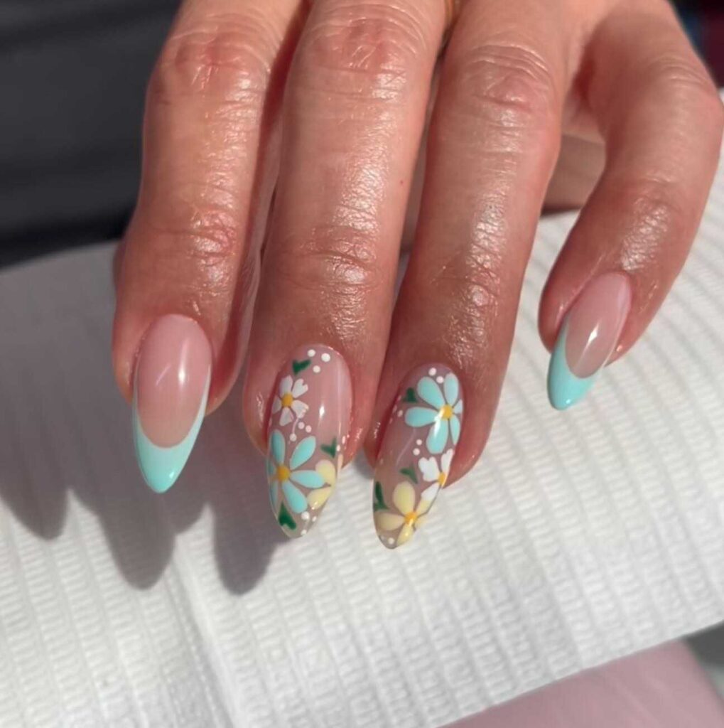 Spring nail design featuring a serene gradient from sky blue to white with delicate floral accents.