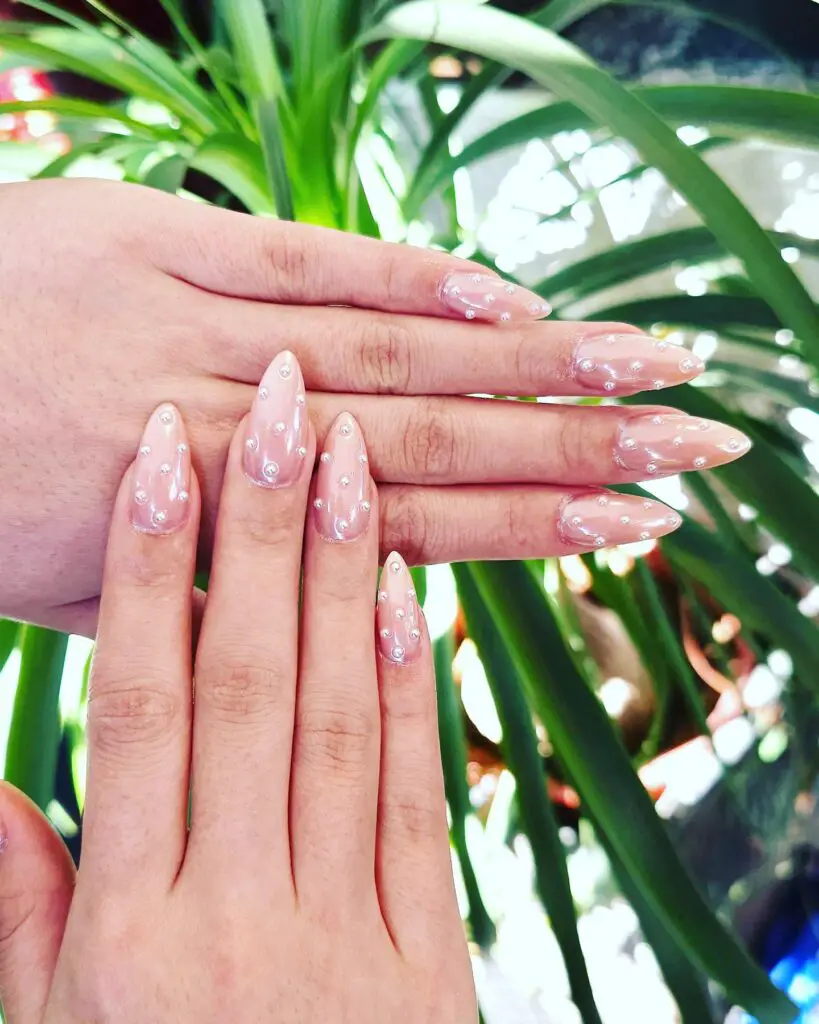 Clear nails with a hint of iridescence and delicate crystal embellishments, perfect for pairing with sparkling accessories.