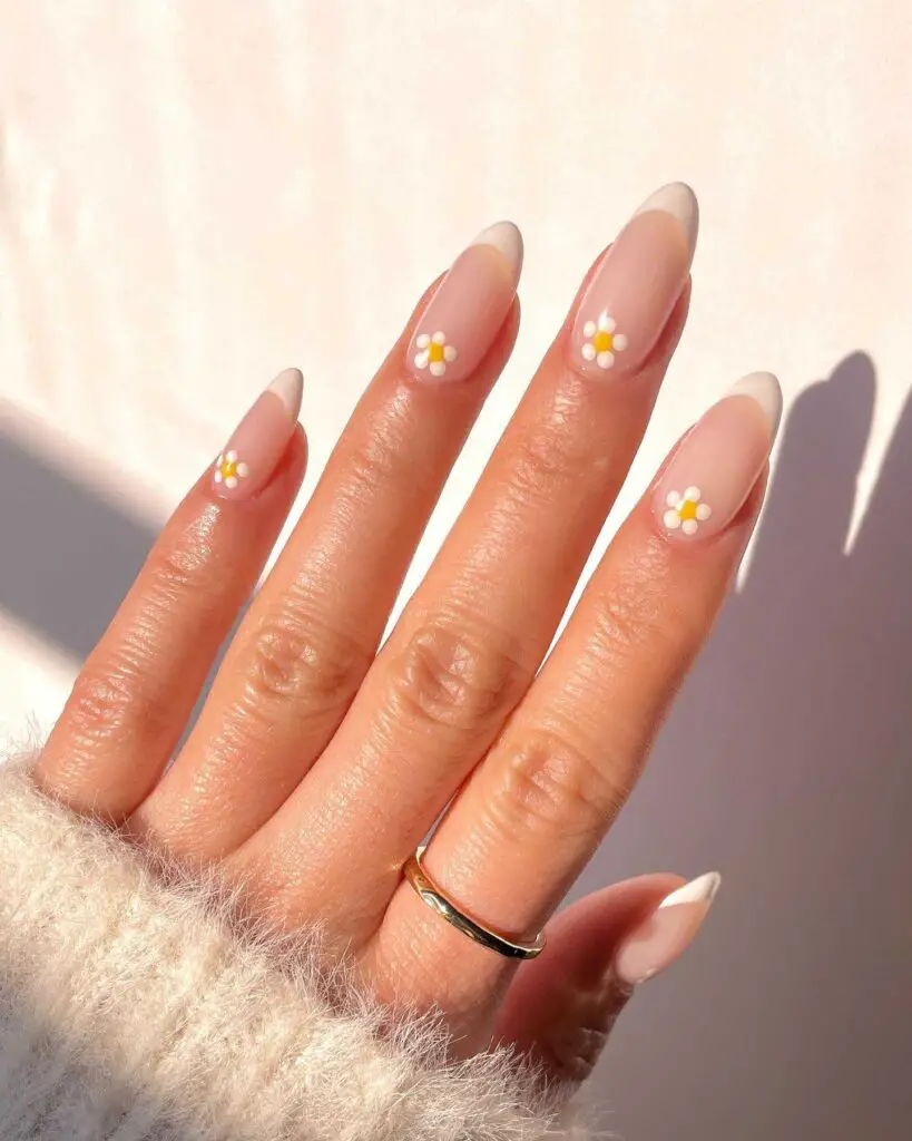 Nude almond nails with small daisy flower accents, capturing the simplicity of spring flowers.