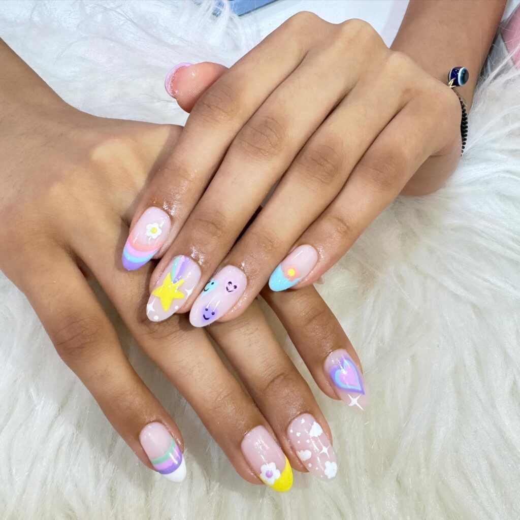 Pastel-colored nails with dreamy designs of stars, hearts, and clouds, capturing the essence of a magical fairytale landscape.