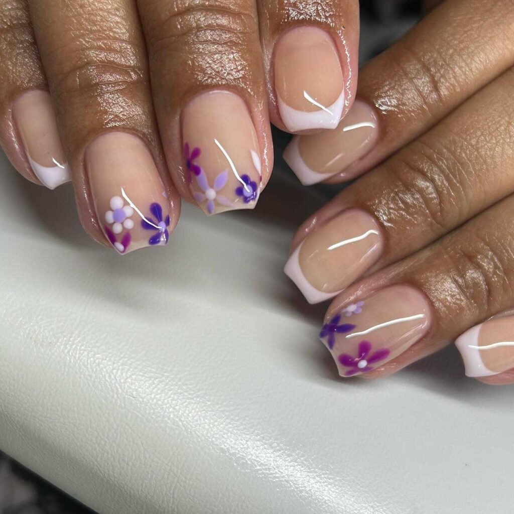 French manicure reimagined with purple floral designs on the tips, infusing a traditional style with springtime charm.