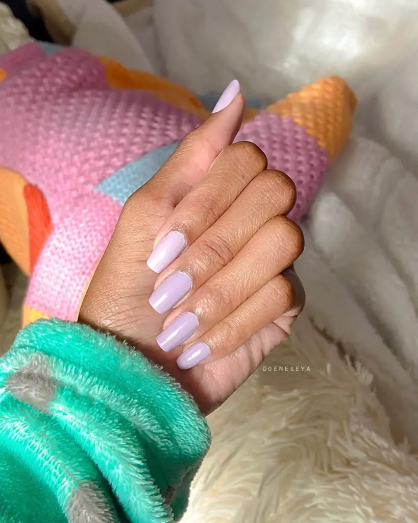 Long, almond-shaped nails painted in a soft lavender shade, offering a glossy finish and spring-inspired elegance.