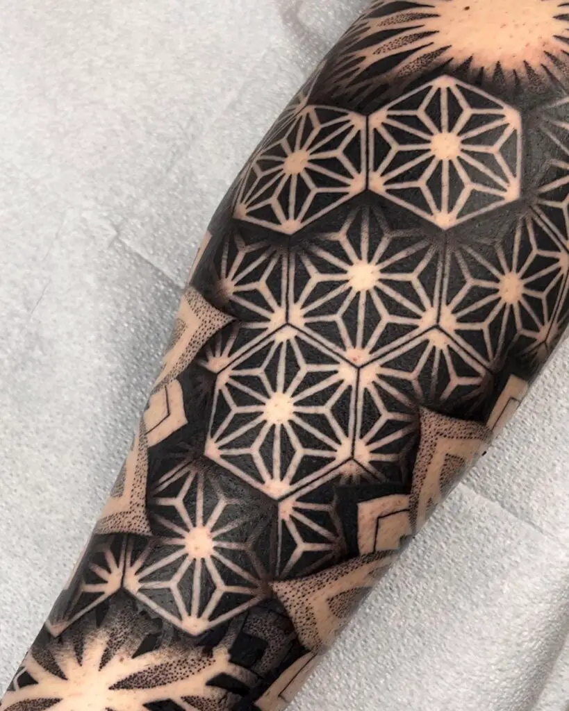 Close-up of a geometric pattern mandala tattoo on the leg with detailed linework and dot shading.