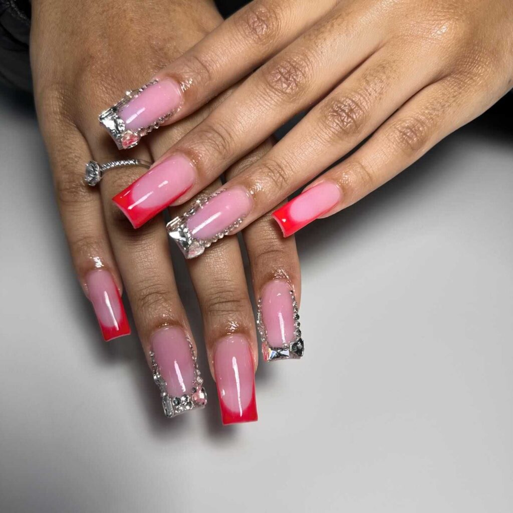 Coffin nails featuring a pink gradient design with luxurious silver glitter and crystal accents for a glamorous effect.
