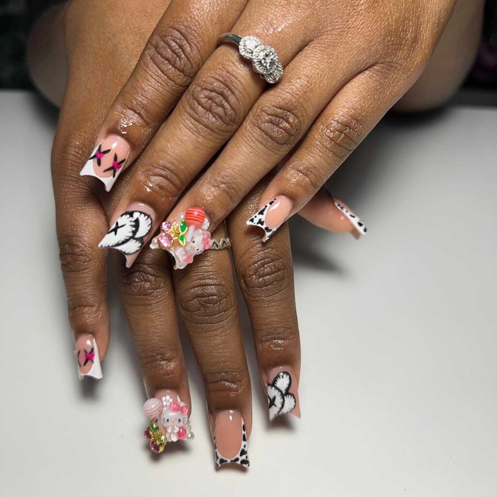 Monochrome nails with black animal prints and pink 3D embellishments, offering a chic and adventurous style.