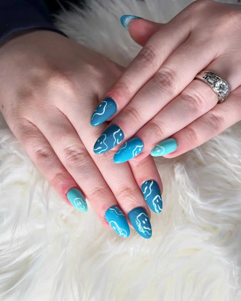 Almond-shaped nails with a blue gradient and white wave accents, capturing the essence of ocean waves.